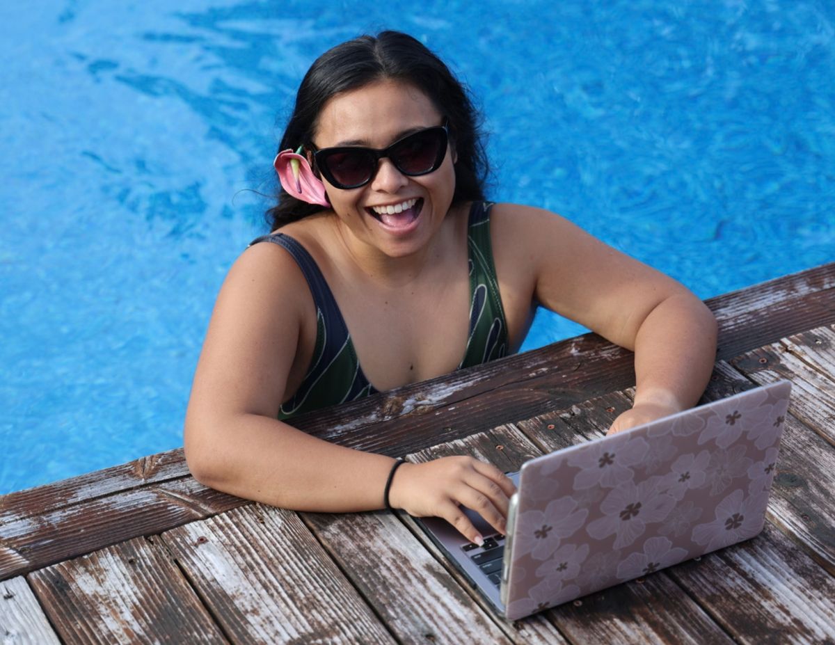 Alexa laughing at her laptop from the pool